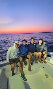 Four anglers on fishing boat at sunset in Milford CT waters