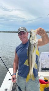 A fisherman with a snook fish caught at Fort Myers Beach
