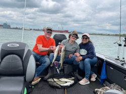 2 fishing rod and reels with 3 people in a boat on the water in MI