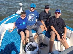 Four people fishing on a boat at Johns Island