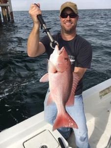 One fisherman posing with a 23-inch fish catch in Alabama