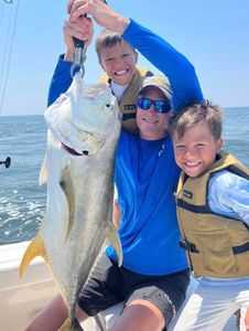 Crevalle jack caught fishing in Gulf Shores AL with two people celebrating the catch