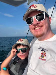 Fishing trip on boat in Gulf Shores AL waters with blue sky and ocean horizon