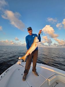 Angler holding large redfish on boat in Gulf Shores AL waters