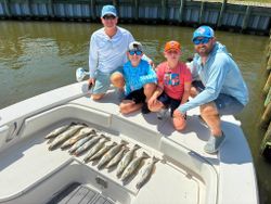 Successful fishing trip in Gulf Shores AL with speckled trout and redfish catch displayed on boat deck