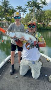 Tarpon fishing catch on boat in Fort Lauderdale FL waters with palm trees
