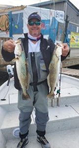 2 fishing rods in hand with a nice catch of 2 fish in TX
