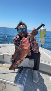 A fisherman holding a red grouper in Pensacola