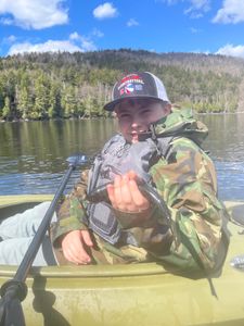 Angler fishing on Saranac River in New York with fishing rod over water