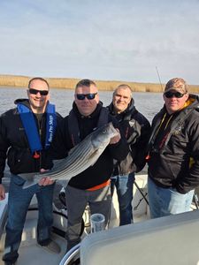 Fishing buddies and a prized striped bass catch!
