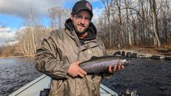A fisherman holding a rainbow trout in NY