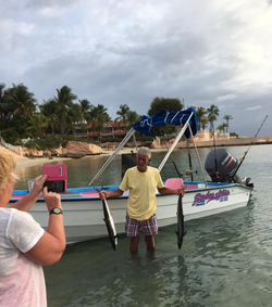 Single angler posing by a large fish in Buccoo