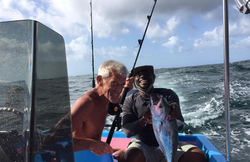 Two people fishing in the waters of Buccoo