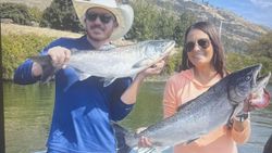Two anglers displaying fresh caught Coho and Chinook salmon from Florida City fishing trip