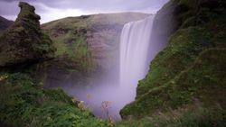 Dramatic waterfall cascading down moss-covered cliffs in lush green landscape near Florida City FL