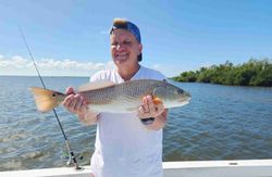 Angler posing with fishing gear in Florida landscape