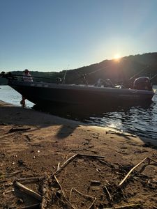 Fishing boat beached on sandy shore at Stillwater MN with fishing rods ready for water sports