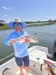 Reeling in a keeper redfish with light tackle on a clear day!