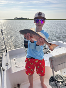 Reeling in a sizzling Redfish on a clear day!