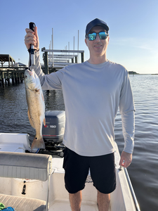 Reeling in a redfish on a clear day in Wilmington!