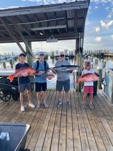 Four people fishing with two big fish at Gulf Shores