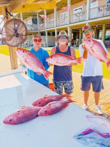 Fresh red snapper catch displayed at Gulf Shores AL fishing dock with cleaning station