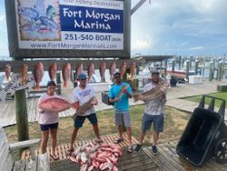 Successful fishing trip at Fort Morgan Marina in Gulf Shores AL with red snapper catch displayed on dock