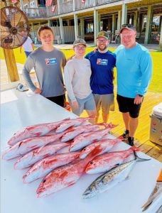Fresh caught red snapper and spanish mackerel displayed on cleaning table at Gulf Shores AL fishing dock