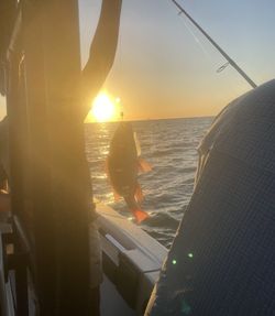 Fishing scene at sunset on Gulf Shores AL waters with fish being caught