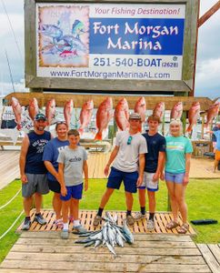 Red snapper fishing catch displayed at Fort Morgan Marina in Gulf Shores AL with multiple fish hanging on dock