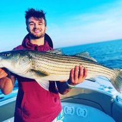A lone fisherman reeling in a big catch in MA