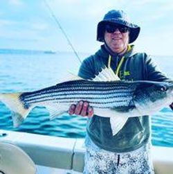 Fisherman holding big 33-inch fish in MA