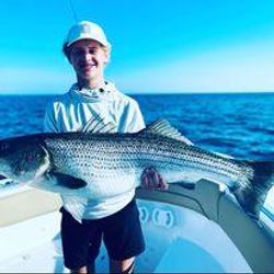 A lone angler landing a sizable catch in MA
