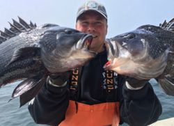 A person fishing in MA with 2 fish