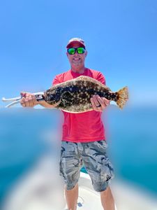 A fisherman holding a large Southern Flounder in Murrells Inlet