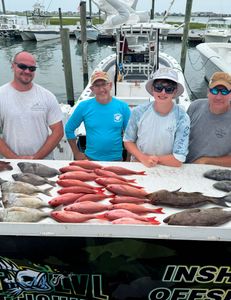 Four people fishing for two big fish