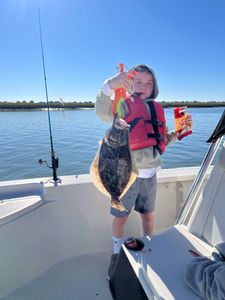 A summer flounder fish caught during fishing at an unknown location.