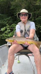 A fisherman holding a large rainbow trout in the state of Arkansas