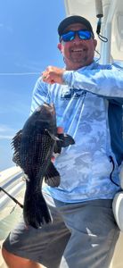 Photograph of a fisherman catching a 17-inch sea bass in NC