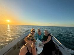 Sunset cruise on calm waters near Chesapeake FL with passengers enjoying refreshments on boat deck