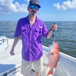 An angler holding a 14-inch fish in Orange Beach