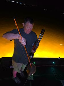 Night fishing scene with fishing rod and equipment on boat in Orange Beach AL