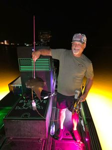 Night fishing scene with illuminated boat deck and fishing equipment in Orange Beach AL