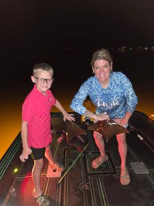 Night fishing scene on boat deck in Orange Beach AL with illuminated equipment