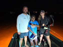Night fishing trip on boat in Orange Beach AL with fishing equipment and bow fishing gear