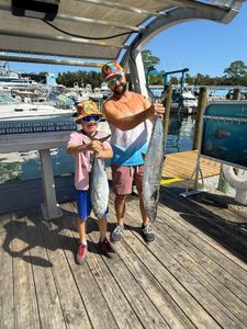 Two anglers with their catch of King Mackerel and Little Tunny in Florida
