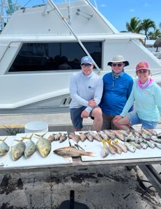 Three people fishing with a single fish in Marathon