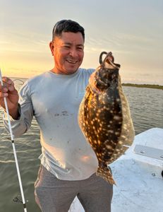 A fisherman holds a large summer flounder fish caught in Matagorda