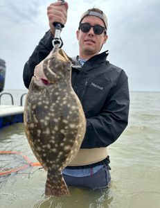 Angler holding a southern flounder fish, fishing in TX