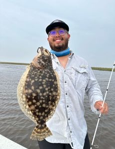 A fisherman holding a large southern flounder caught in Matagorda